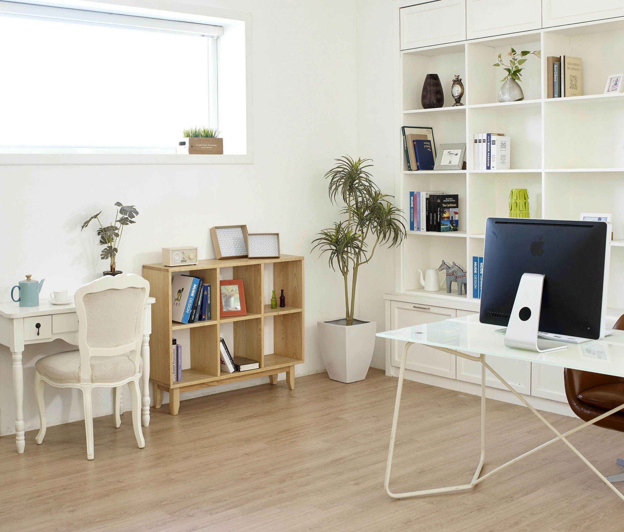 Eingerichtetes Arbeitszimmer mit hellen Möbeln und heller Wandfarbe